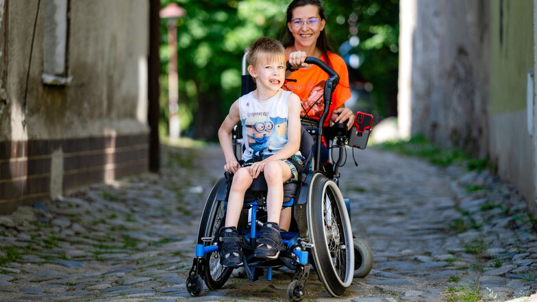 Jeannette Weich und ihr Sohn Jonathan sitzen beide im Rollstuhl. Die Kopfsteinpflaster-Buckelpiste vor der eigenen Haustür ist für die Zwei eine echte Herausforderung.