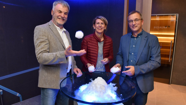 Oberbürgermeister Uwe Rumberg (links), Aufsichtsratsvorsitzende Katrin Reis und Geschäftsführer Jörg Schneider spielen mit dem Schnee in der neuen Saunalandschaft.