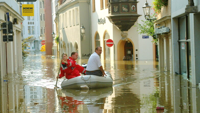 Sandra Knorr und Ronny Kunze von der Wasserwacht paddeln vorsichtig mit einem Schlauchboot durch die überflutete Altstadt in Meißen 2002.