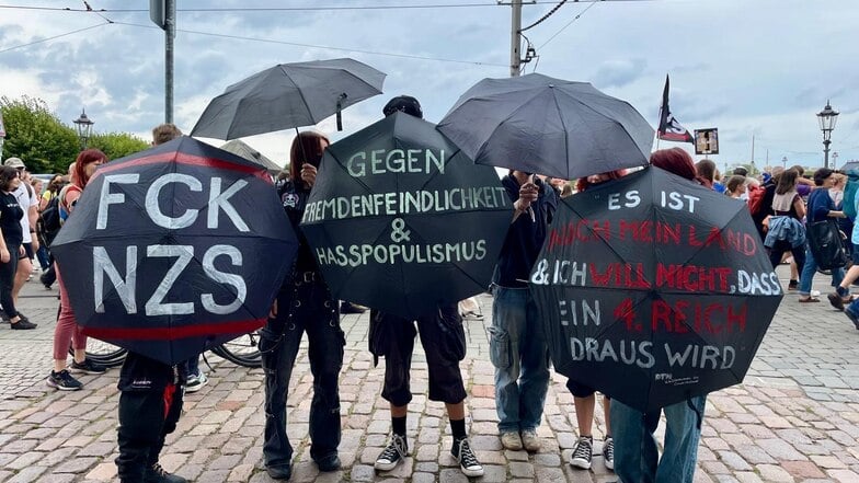 Die Demogruppe "Fred die linke Socke" hat Regenschirme als Transparente umfunktioniert, um gegen Rechtsextremismus zu demonstrieren.