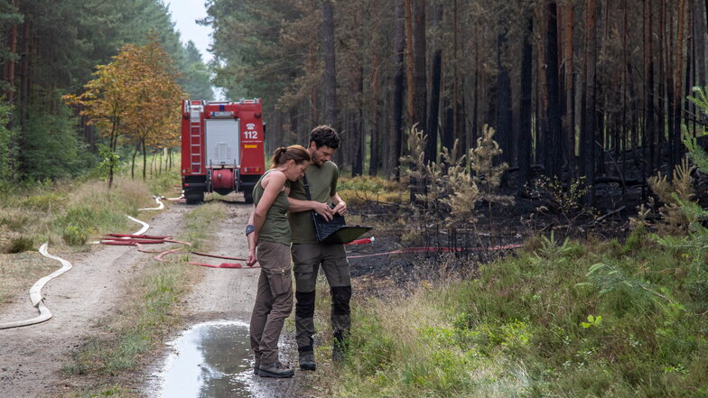 Mitarbeiter vom Staatsbetrieb Sachsenforst messen die Fläche des Waldbrandes. 2,6 Hektar sind davon betroffen.