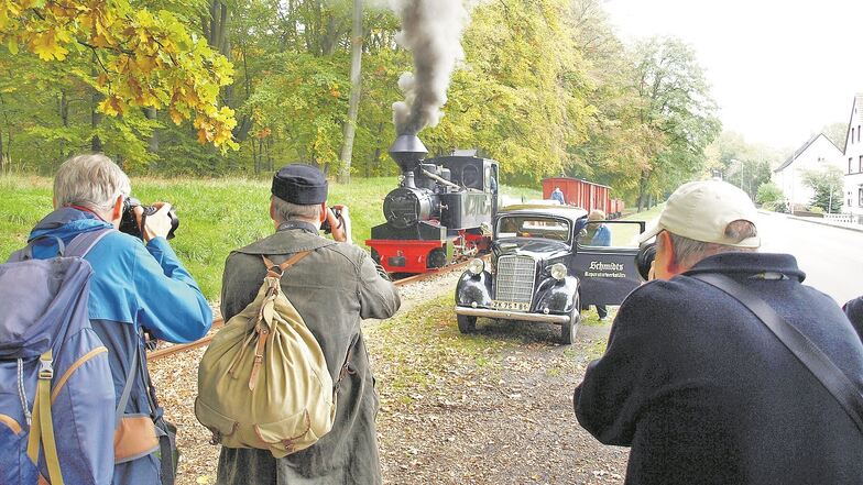 Eine historische Dampflok samt Waggons von der Waldeisenbahn Muskau neben einem Oldtimer: Das sind die Motive, die Teilnehmer von Fotozug-Reisen erwarten und beglücken.