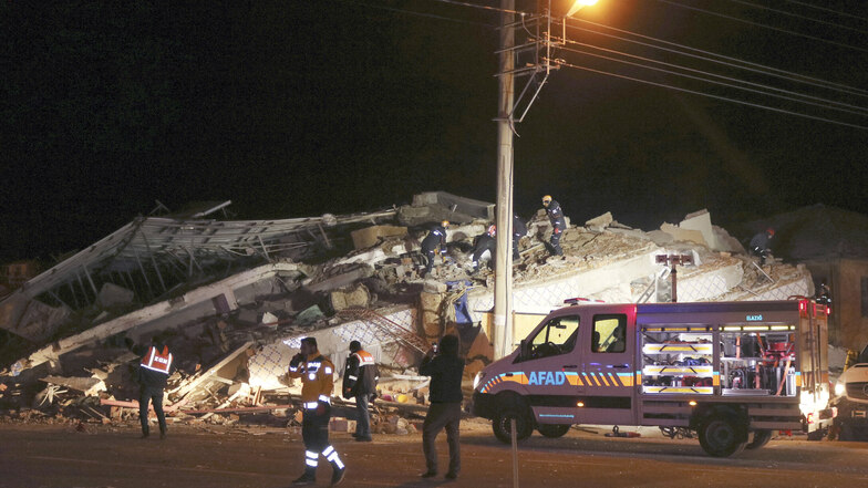 Rettungskräfte suchen an einem eingestürzten Gebäude nach verschütteten Opfern eines Erdbebens. 