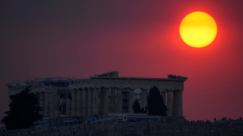Der Rauch eines Waldbrandes in den Außenbezirken von Athen bedeckt die über der Akropolis untergehende Sonne.