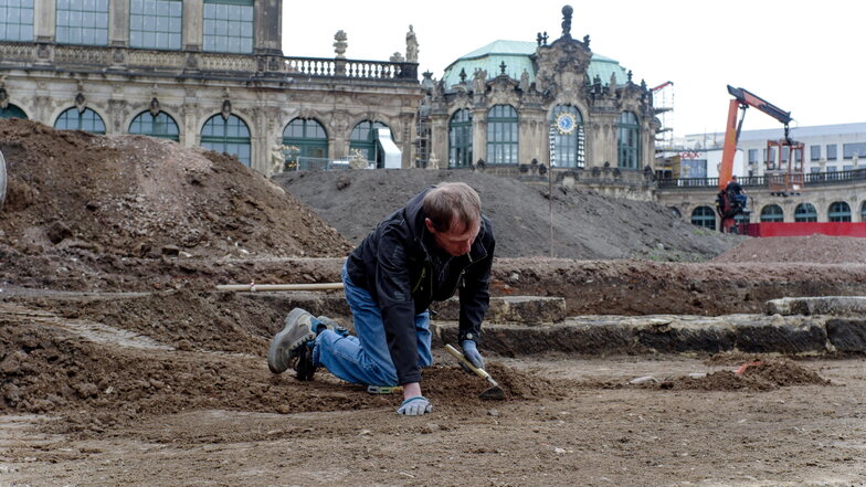 Während die Archäologen alte Mauern und andere Bauteile untersuchen, ist Grabungsarbeiter Fred Seidel dabei, weitere Bereiche im Zwingerhof vorsichtig freizulegen.