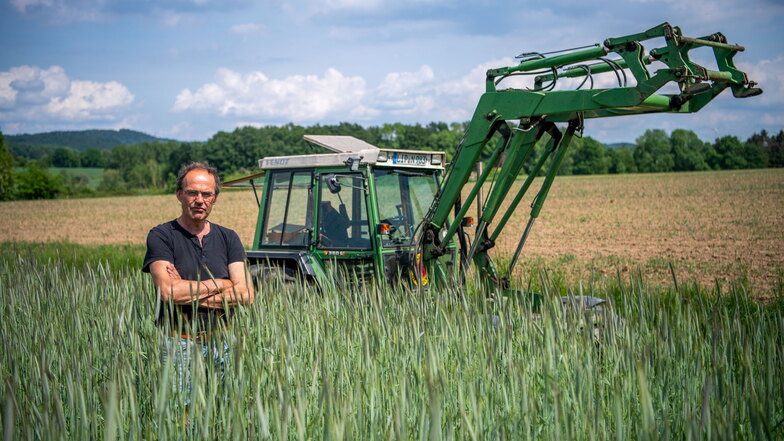 Ulf Allhoff-Cramer steht in einem Roggen-Feld vor seinem Traktor. Der Bio-Bauer macht VW mitverantwortlich für Schäden an seinem Hof.