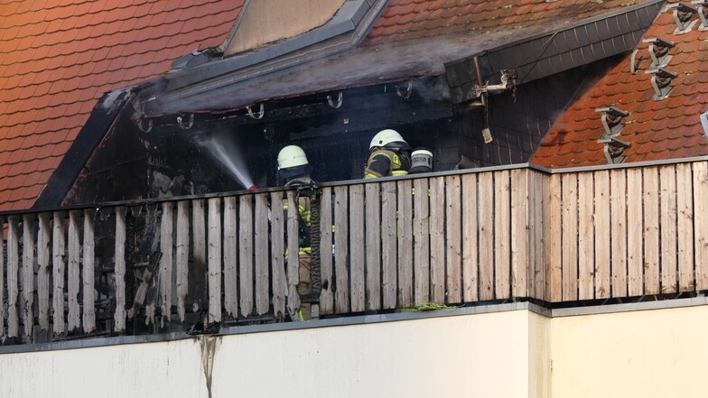 Feuerwehrleute löschen einen Balkonbrand in Wurzen.