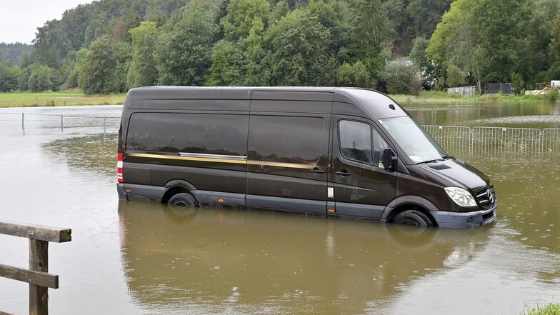 Österreich, Uttendorf: Ein Transporter steckt auf einer überfluteten Straße im Bezirk Braunau fest.