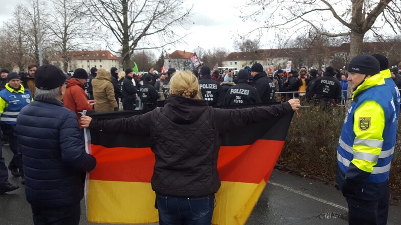 Eine Frau mit Deutschland-Fahne empfängt die Demonstranten.