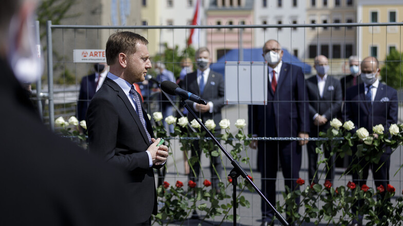 Sachsens Regierungschef Michael Kretschmer beim Kriegsgedenken auf der Görlitzer Altstadtbrücke. Hinter dem Zaun die Vertreter Polens.