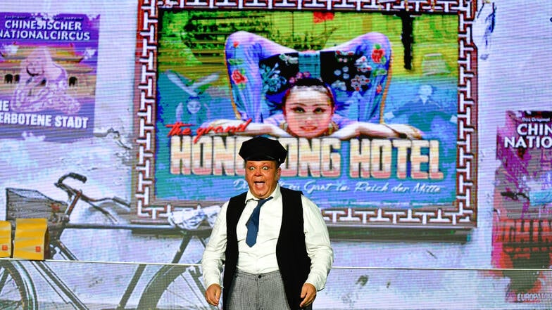 Ein energiegeladener Auftritt bei der Premiere von China Girl am 11. September 2024 – mit Raoul Schoregge als lebhaften Clown vor dem Plakat des Hongkong Hotels .