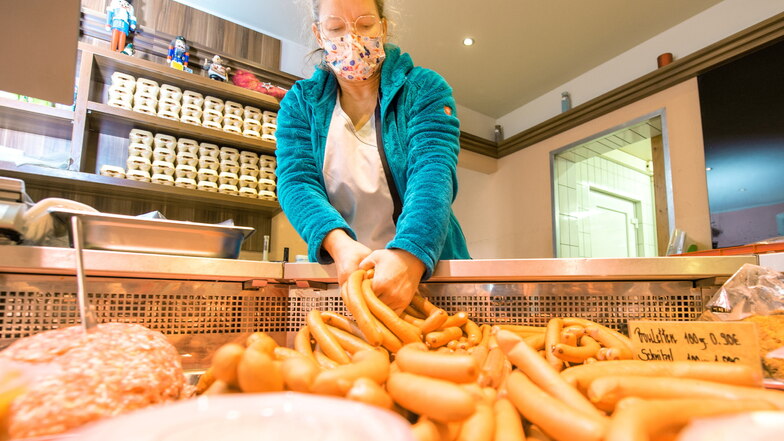 Chefin Ramona Schick legt Würstchennachschub in die Kühltheke des Ladens in Pirna-Copitz. Wiener sind deutschlandweit das beliebteste Essen zu Heiligabend.