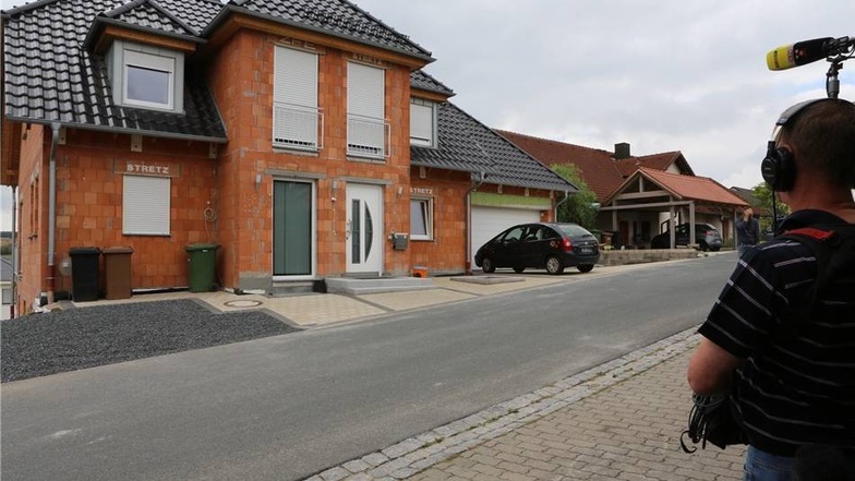 In einem Ort bei Bamberg (Bayern) und in Dresden werden zwei Verdächtige im Alter von 39 und 61 Jahren festgenommen. Das Foto zeigt das Haus in Bayern.