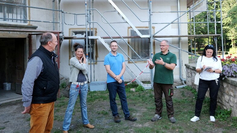 Groli-Geschäftsführer Marco Müller (2. v. r.) aus Dresden erklärt, wie seine Firma die Begasung im Wasserschloss durchführt. Links neben ihm steht Jens Kutschke vom Förderverein des Gebäudes und ganz links hört Bürgermeister Thomas Claus aufmerksam zu.