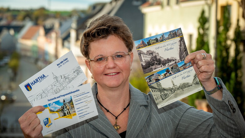 Claudia Erbert, Leiterin der Arbeitsgruppe Festschrift und Werbung, hält Postkarten und Flyer für die 800-Jahr-Feier in Hartha in den Händen.
