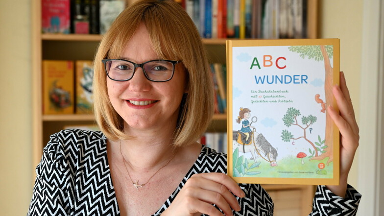 Anja Schenk mit dem Sammelband „ABC Wunder“ in ihrem Haus in Kurort Hartha.