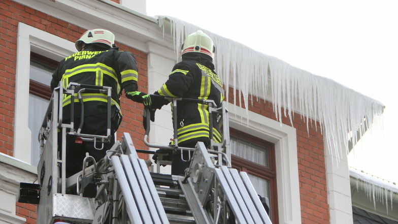 Gefährliche Last: Feuerwehrleute entfernen an einem Haus in der Gartenstraße Eiszapfen.