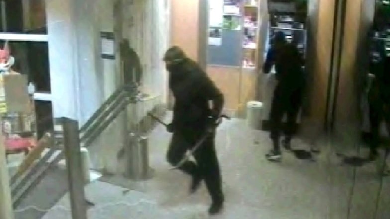Auf dem Videoausschnitt ist zu sehen, wie zwei vermummte Täter in einer Bankfiliale in Forchheim einen von ihnen aufgehebelten Geldautomaten mit einem Sprengsatz versehen.