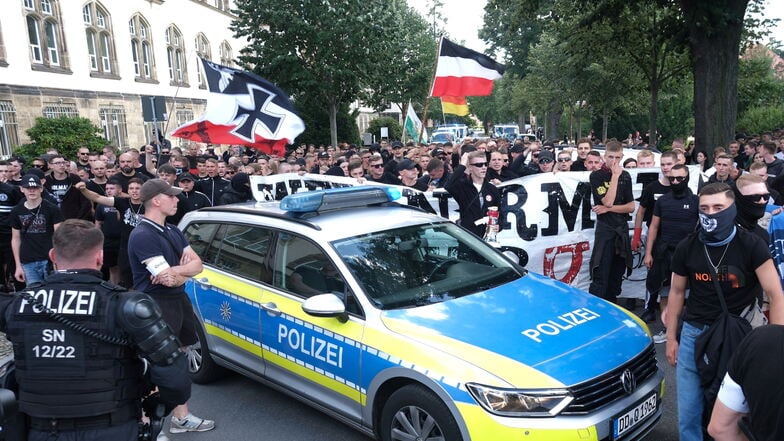 Teilnehmer einer rechten Demonstration werden in Bautzen von Polizisten begleitet.