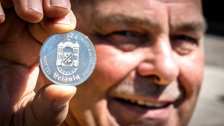 Heimatvereinschef Uwe Reichel ist mit der Probe-Prägung der Altstadtfest-Medaille zufrieden. Das Motiv 2024 zeigt die Realschule Leisnig.