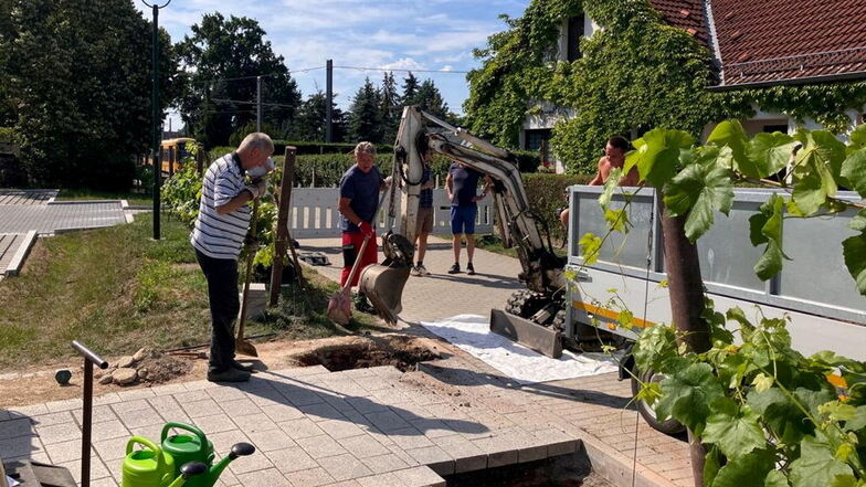 Hans Wägerle und Dr. Reinhard Becker graben das Loch für das Fundament. Maik Erler und Detlef Arnold werden vom Bagger verdeckt, den Maik Marx bedient.