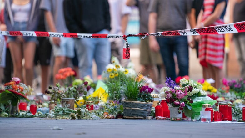 Würzburg: Trauerkerzen und Blumen liegen vor einem Kaufhaus in der Innenstadt, in dem ein Mann Menschen mit einem Messer attackiert hatte.