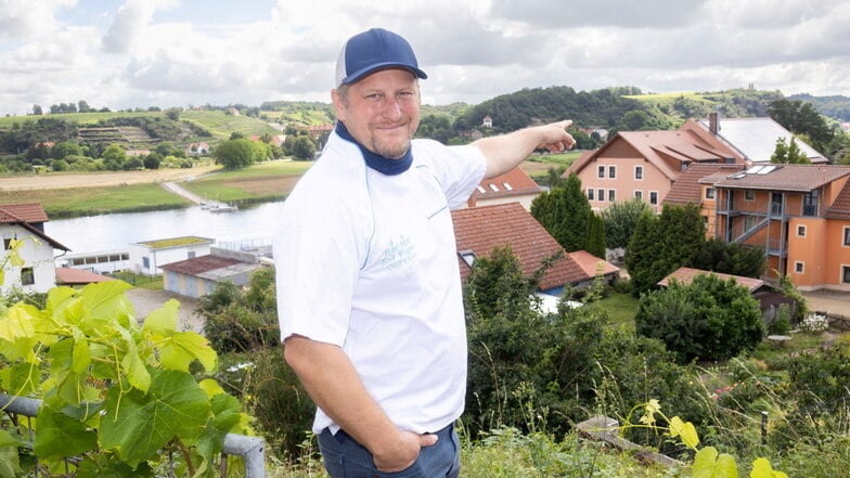 Erik Wagner zeigt auf das Solardach seiner "Elbklause" in Niederlommatzsch. Damit erzeugt er eigenen Strom. Besonders Spülmaschinen  benötigen viel Energie. Das ist für Wagner nun günstiger.