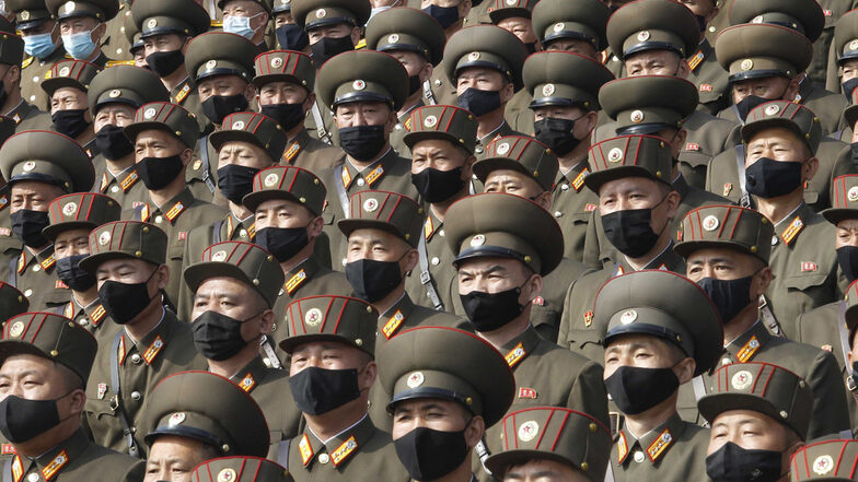 Soldaten mit Mund-Nasen-Schutz und Uniform stehen zur Begrüßung des 8. Kongresses der Arbeiterpartei Koreas auf dem Kim-Il-Sung-Platz.