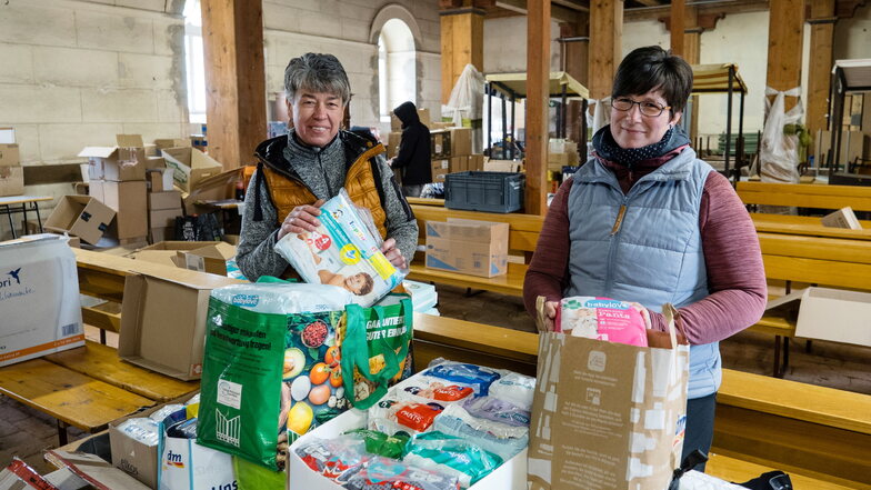 Simone (links) und Katrin Drescher sortieren in der Unterkirche in Kunnerwitz Spenden für die Ukraine. Am Freitag wurden alle Pakete in zwölf Transporter verladen, die sich am Abend in Richtung Osten in Bewegung setzten.