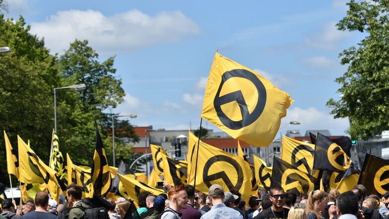 Anhänger der "Identitären Bewegung" stehen mit Fahnen bei einer Demo in Berlin. Einige Anhänger der rechtsextremen Bewegung haben nun vor einer Kanzlei in Dresden protestiert.