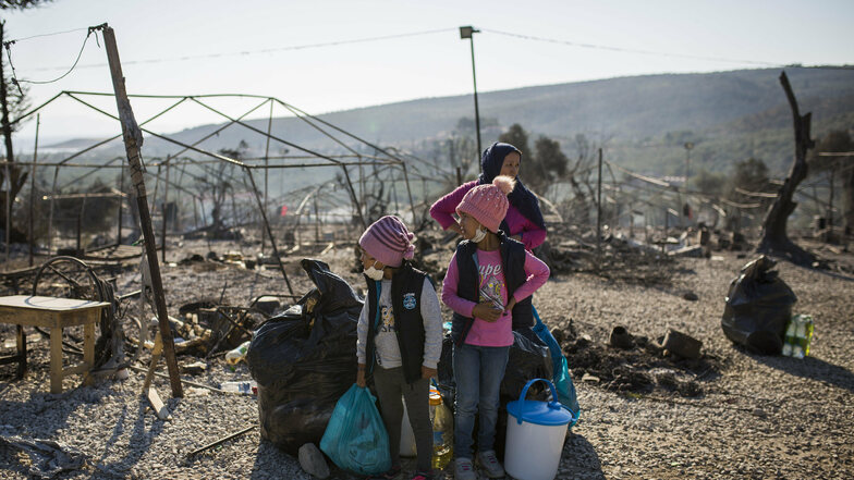 Eine Familie steht innerhalb des ausgebrannten Flüchtlingslagers Moria. Zuletzt hielten sich in Moria und unmittelbarer Umgebung etwa 12.500 Migranten auf.