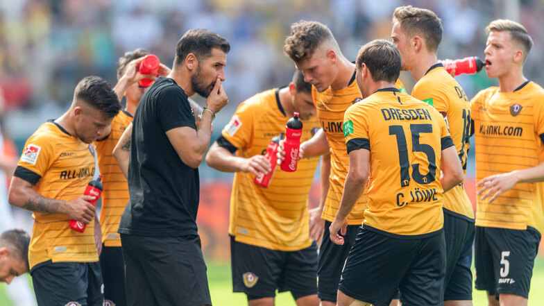 Dynamos Trainer Cristian Fiel nachdenklich mit seinen Spielern in einer Trinkpause. 