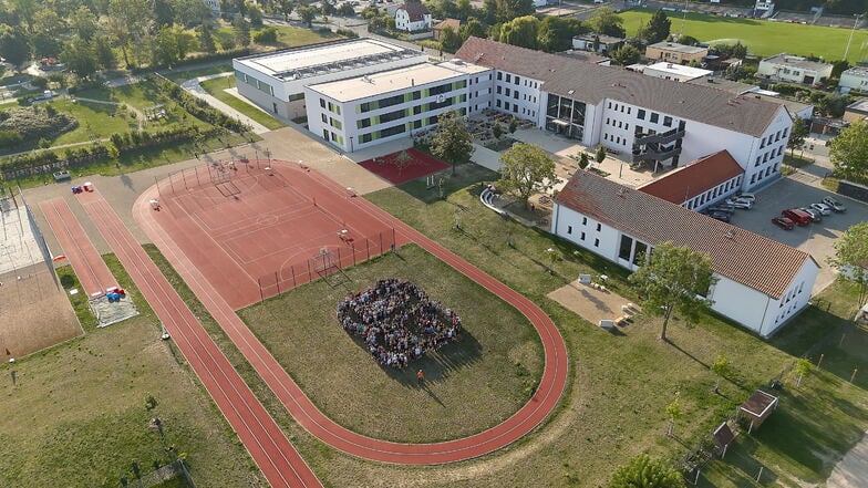 Das Schulgelände an der Merzdorfer Straße: Auf dem Sportplatz haben Schülerinnen und Schüler eine "60" gestellt.