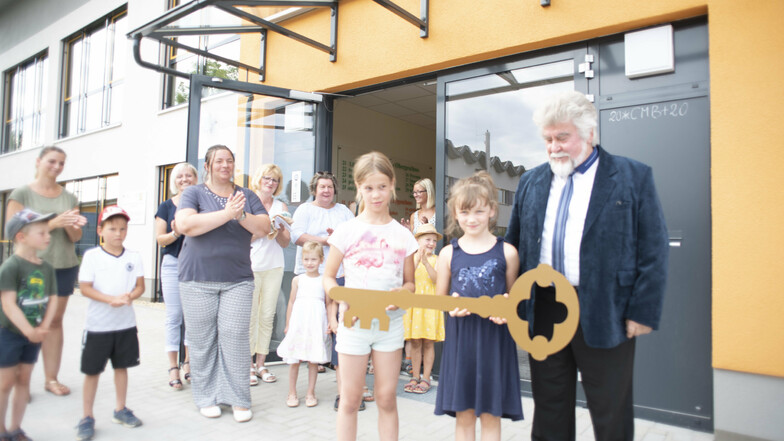 Mit einem großen Schlüssel nahmen Kinder des neuen Hortes Räckelwitz das neue Gebäude in Besitz. Bürgermeister Franz Brußk (r.) freut sich mit ihnen.