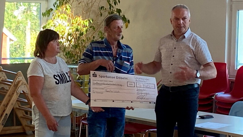 Bürgermeister Dirk Schilling übergibt Jacqueline und Uwe Wiatr den Spendenscheck.
