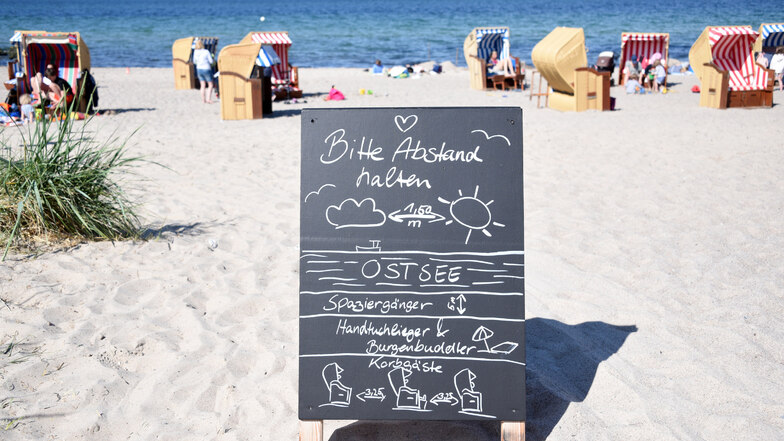 Schleswig-Holstein, Niendorf: Ein Schild mit der Aufschrift "Bitte Abstand halten" steht am Zugang zum Strand an der Ostsee.