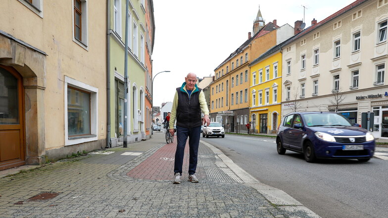 Dietrich Thiele zeigt auf den Splitt, der seit Wochen auf dem Geh- sowie Radweg an der Äußeren Weberstraße beim Abzweig zum Ring in Zittau liegt. Den hat er schon einmal weggemacht, will das aber nicht mehr.
