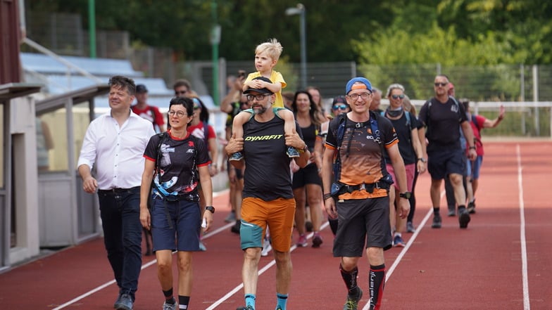 So kam Henrik Gomille (vorn rechts) nach seinem 100-Kilometer-Marsch im Zittauer Weinau-Stadion an. Auf den letzten Metern wurde er unter anderem von OB Thomas Zenker (links) begleitet.