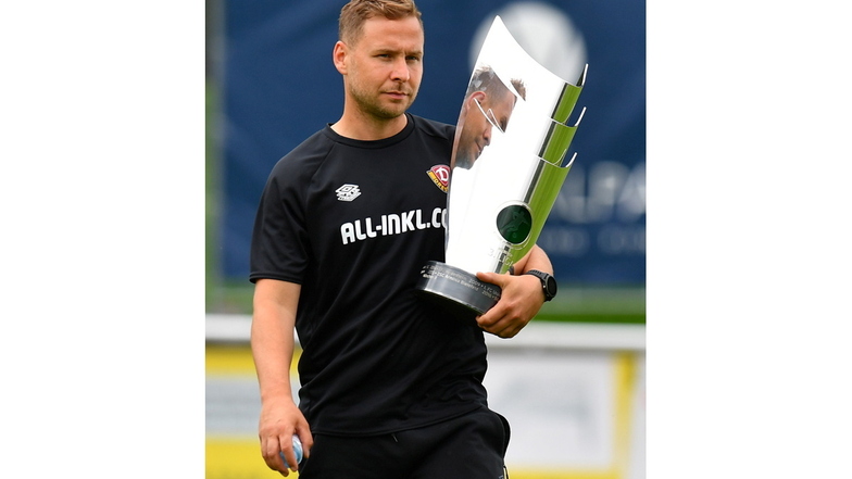 Henry Buschmann hält den Pokal für den Drittliga-Meister 2021 im Arm. Als Pressesprecher und Fan hat er Dynamo auf eine sehr emotionale Weise begleitet.