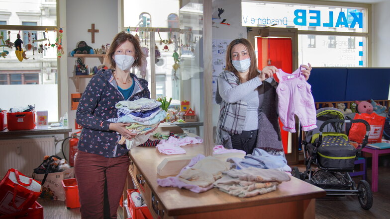 Annegret Mühl (l.) vom Kaleb-Zentrum kämpft um Gelder für die Kleiderkammer in der Bautzner Straße 52 - nicht zuletzt auch für Faten aus Syrien, die dort Kleidung für ihren kleinen Sohn erhält.