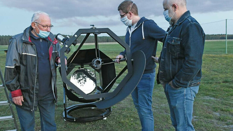 Die Vereinsmitglieder der Lausitzer Sterngucker Horst Noack, Aron Reckzeh und Mattheus Freimut am vereinseigenen Spiegelteleskop auf dem Modellflugplatz.