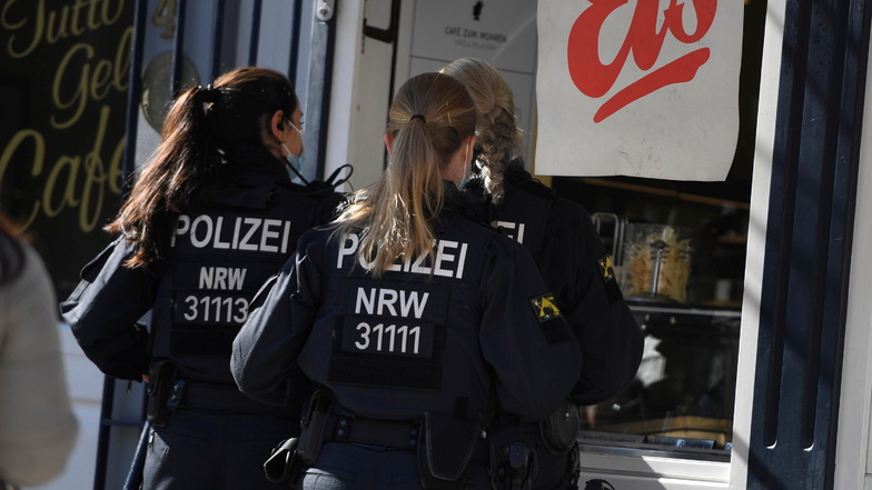 Polizistinnen stehen in der Innenstadt von Aachen bei schönem sonnigen Wetter an der Eisdiele an.