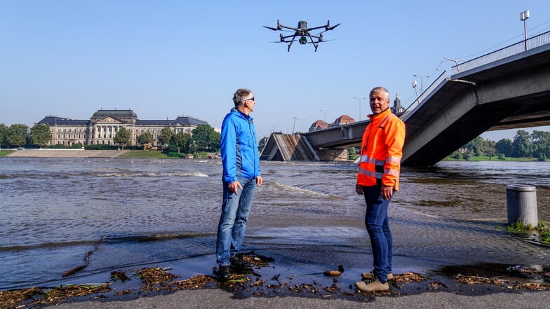 Jens Focke (rechts), Abteilungsleiter des Bereichs Geodatenerfassung der Stadt Dresden, und Hochwasserexperte Horst Ullrich vom Umweltamt untersuchen den Wasserspiegel der Elbe.