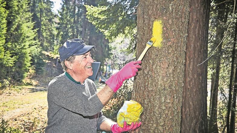 Kreiswegewart Peter Mildner erneuert vorm Saisonstart die gelbe Markierung des Forststeiges.