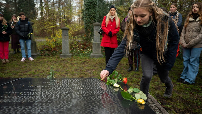 Eine Schülerin aus Görlitz legt eine Rose auf der Grabtafel der verstorbenen griechischen Soldaten ab.