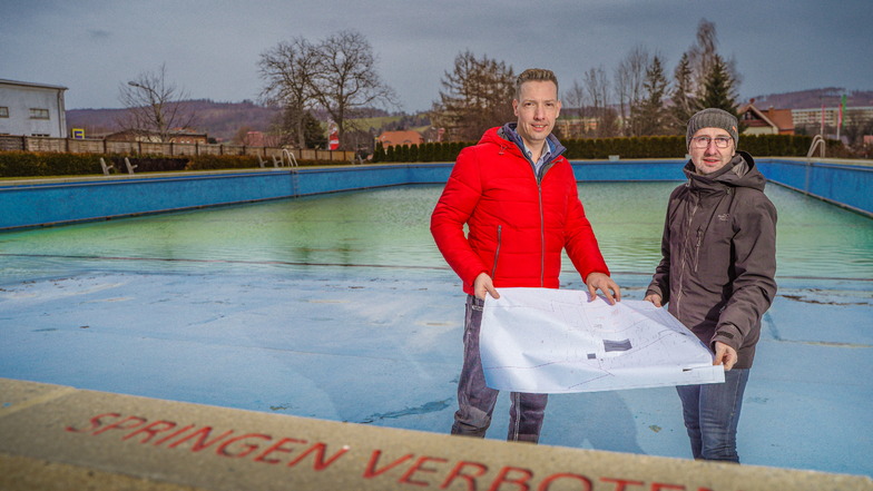 Wilthens Bauamtsleiter Heiko Knoppik (r.) und Bürgermeister Michael Herfort (CDU) stehen im großen Becken des Wilthener Freibades. Das ist porös und soll in diesem Jahr saniert und umgebaut werden.