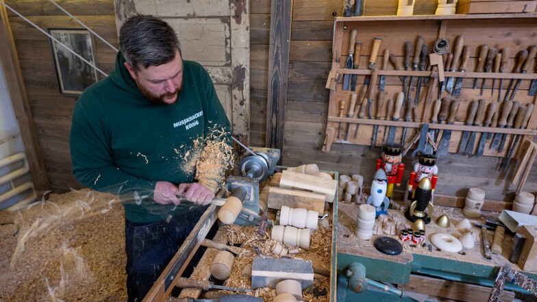 Holzspielzeugmacher Markus Füchtner drechselt in seiner Werkstatt in Seiffen. Ein halbes Jahr haben Wissenschaftler des Fraunhofer-Instituts für Werkzeugmaschinen mit dem Team um Füchtner getüftelt. Jetzt im Advent heben sie den Vorhang für den Prototyp i