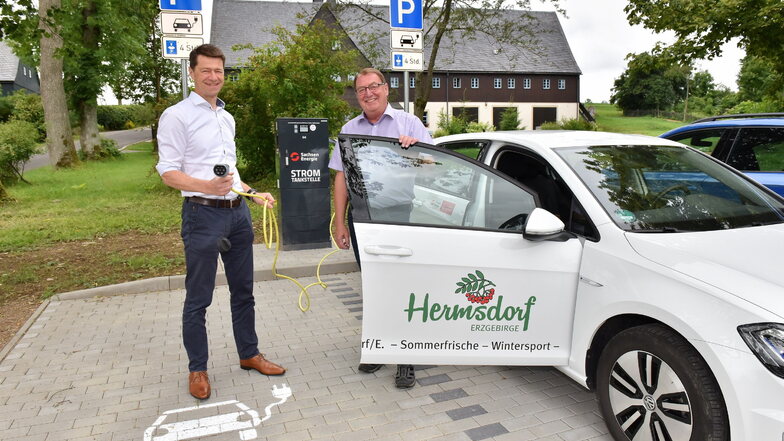 Gunnar Schneider von Sachsen Energie übergibt in Hermsdorf/E. die neue Ladesäule und einen Elektro-Golf an Bürgermeister Andreas Liebscher.