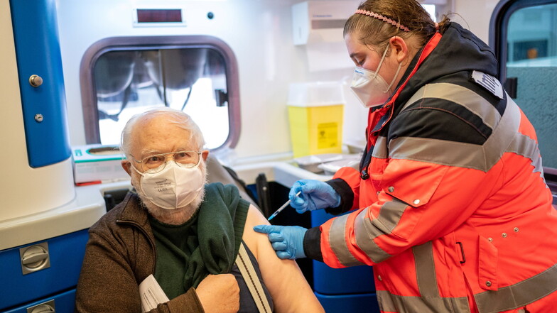 Ein Mann bekommt von der Mitarbeiterin eines mobilen Impfteams eine Corona-Schutzimpfung verabreicht.