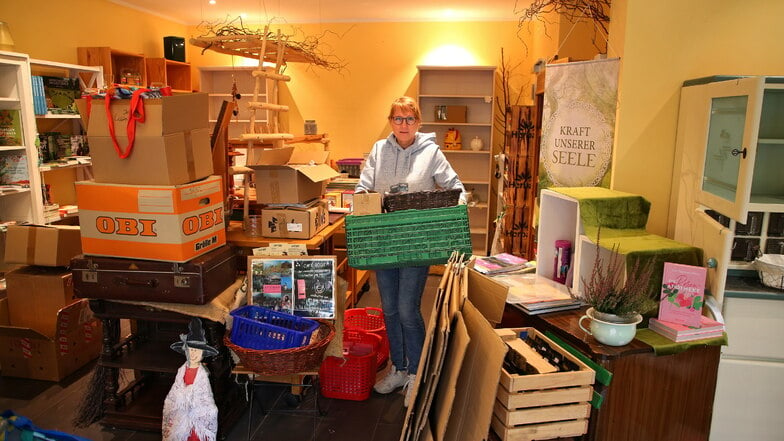 Konstanze Bittner vom Geschäft Naturwaren Hollerbusch auf dem Markt in Bad Schandau räumt mit Helfern vorsorglich den Laden aus.